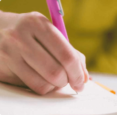 Hand writing with a pink pen