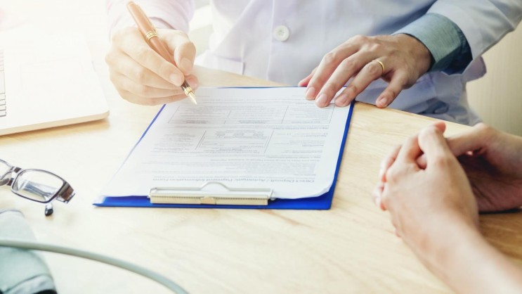 Arzt beim Ausfüllen eines Formulars