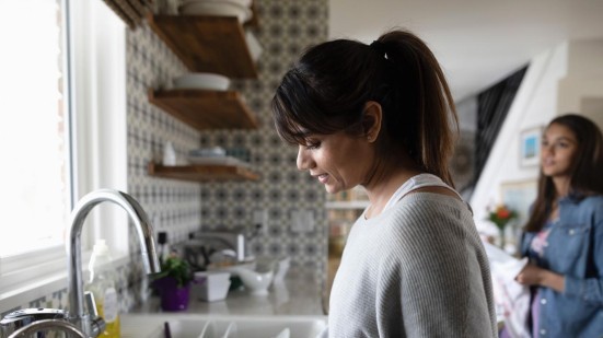 Frau mit Tochter beim Abspülen