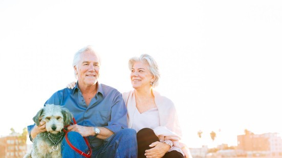 Aktives Paar mit Hund am Strand