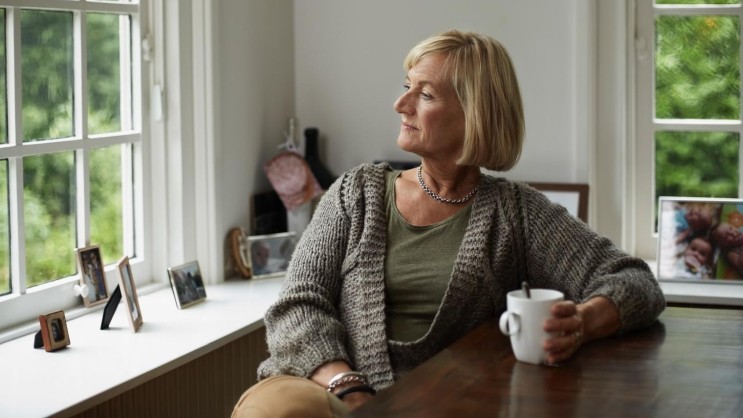 Frau sieht nachdenklich aus Fenster