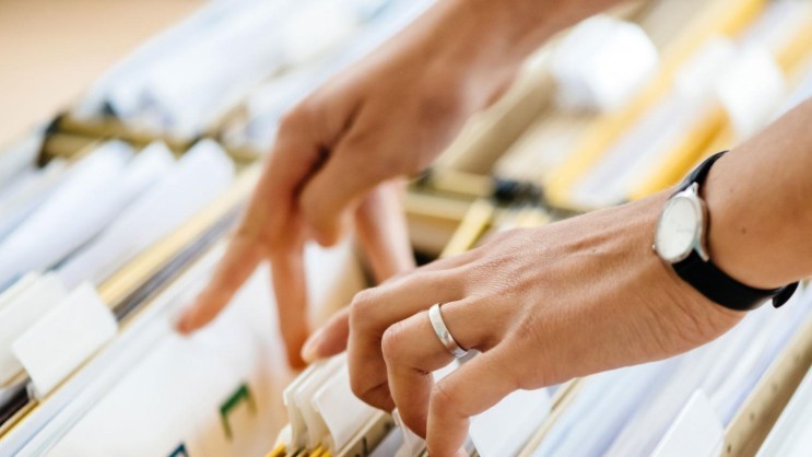 Hand blättert durch Akten
