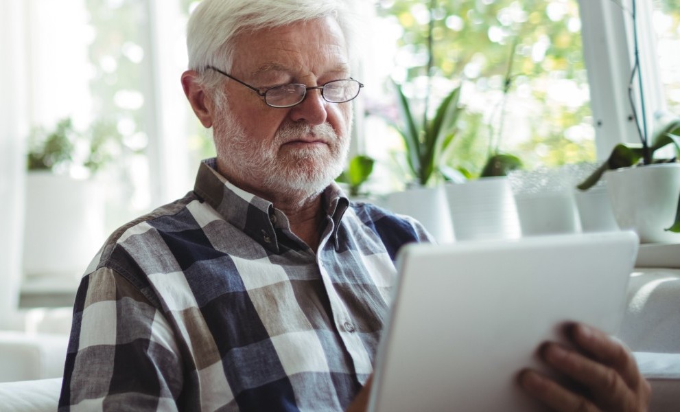 Unterstützung für Ihr WohlbefindenMann zu Hause mit Tablet