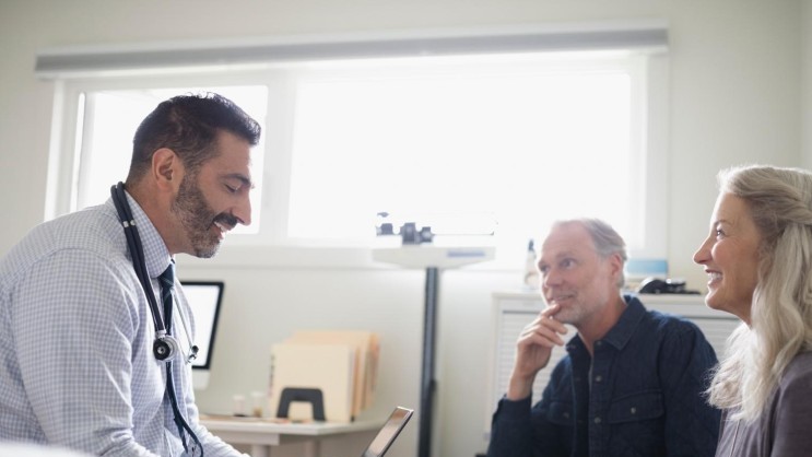 Paar im Arztgespräch in entspannter Atmosphäre