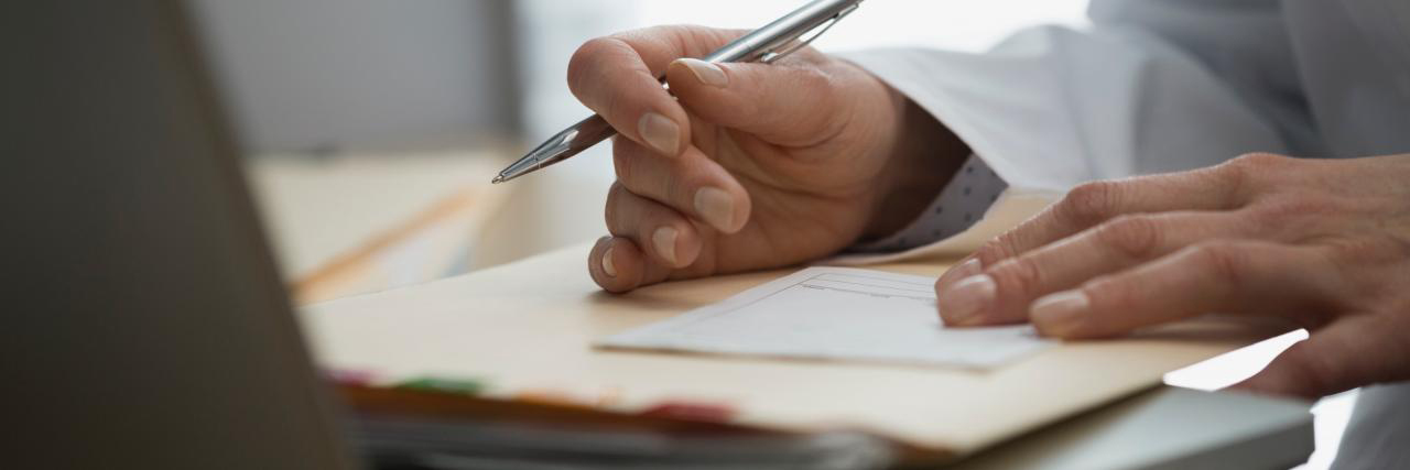 Arzthand beim Unterschreiben eines Attests