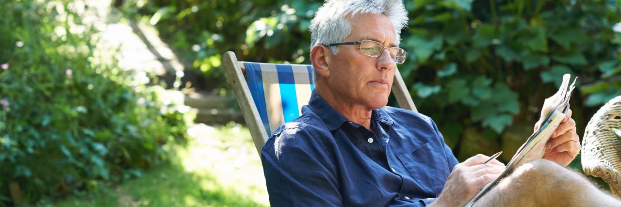 Mann im Liegestuhl beim Rätsel-Lösen