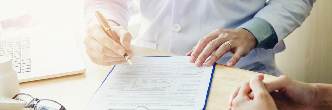Arzt beim Ausfüllen eines Formulars
