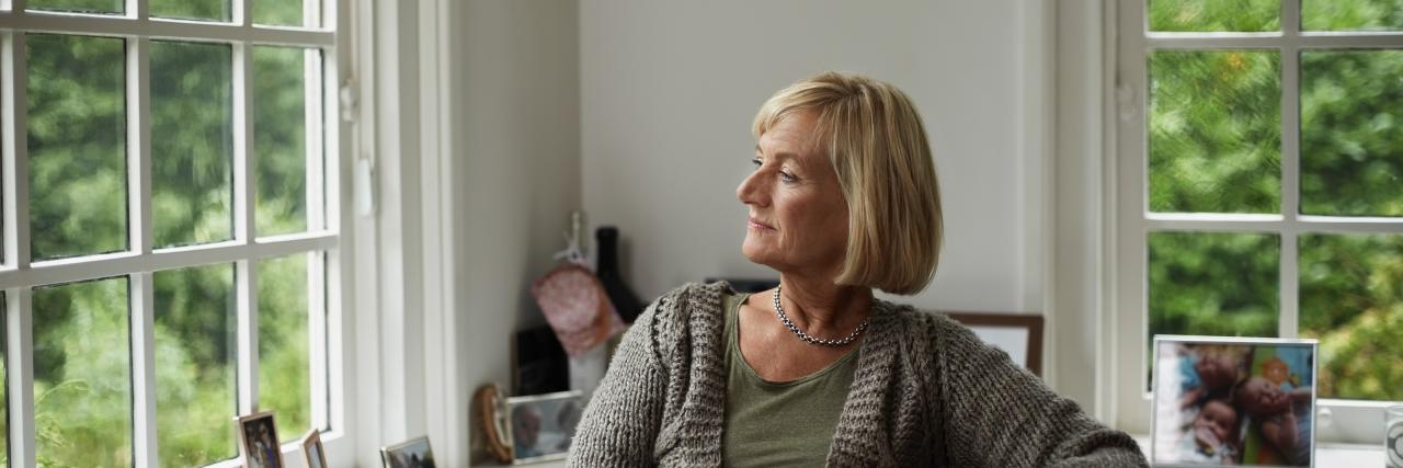 Frau sieht nachdenklich aus Fenster