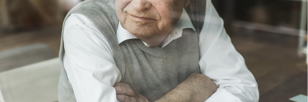 Senior blickt durch ein Fenster